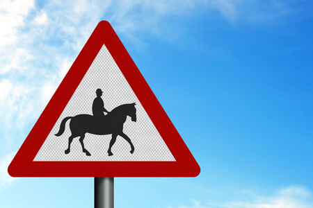   Triangle shaped street sign with person riding on a horse